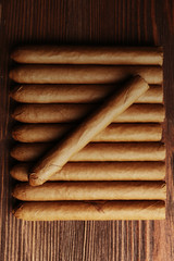 Cigars on wooden table, top view