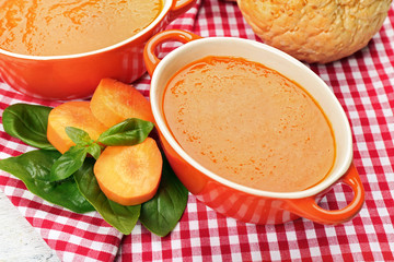 Carrot cream-soup with buns on table close up