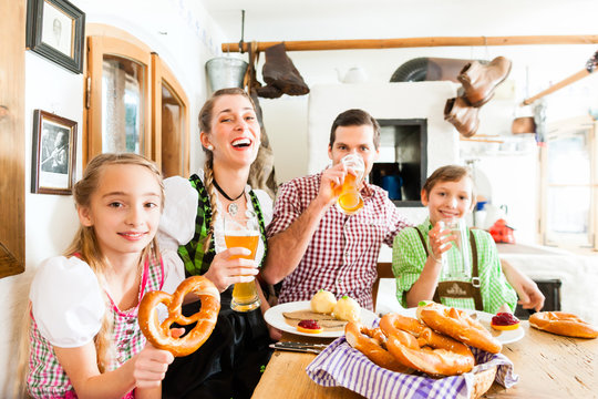 Bayrisches Mädchen im Dirndl beim Essen mit Familie im Restaurant