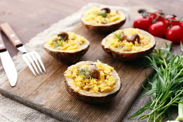 Baked potatoes with cheese and mushrooms on table close up