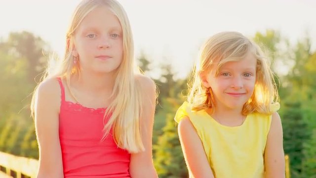 Young blonde sisters playing outside