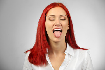 Beautiful young woman on gray background