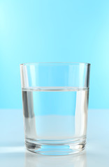 Glass of water on blue background
