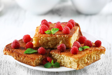 Fresh pie with raspberry in white plate on wooden table, closeup