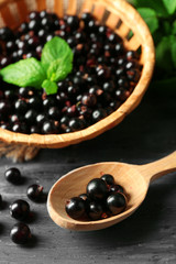Ripe black currant on wooden background
