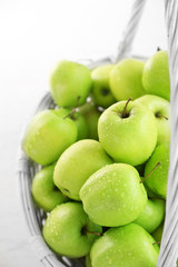 Green apples in wicker basket, closeup