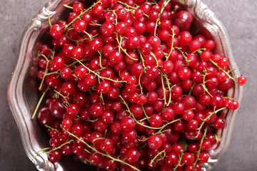 Ripe red currants in metal bowl on table, top view
