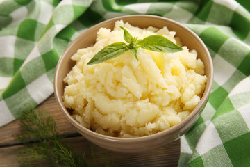 Mashed potatoes in bowl on table with checkered napkin, closeup