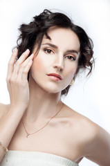 Naklejka premium Studio portrait of a beautiful brunette with evening hairdo and