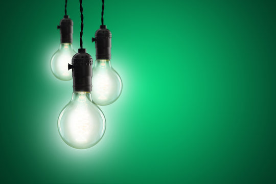 Idea concept - Vintage incandescent bulbs on green background