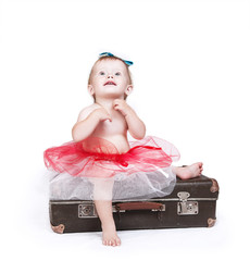Little girl in tutu skirt sitting on the retro suitcase © Soloviova Liudmyla