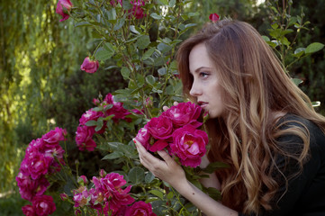 Fototapeta premium Beautiful young woman with auburn hair and green eyes admiring r