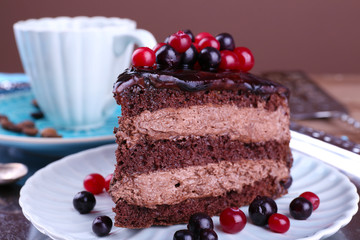 Delicious chocolate cake with berries on plate on table close up