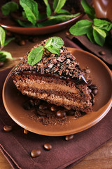 Delicious chocolate cake with mint on plate on table close up