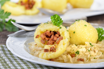 Österreichische Grammelknödel auf warmem Krautsalat rustikal serviert