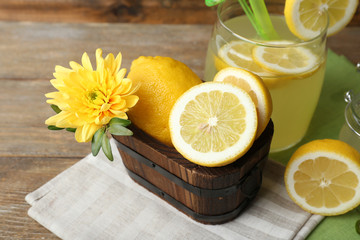 Still life with lemon juice and sliced lemons on wooden background