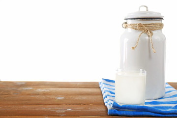 Retro can for milk and glass of milk on wooden table, on white background