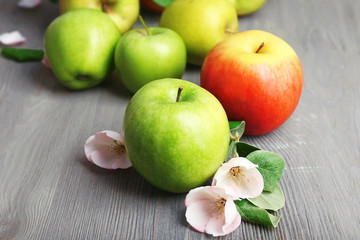 Fresh apples with apple blossom on wooden table