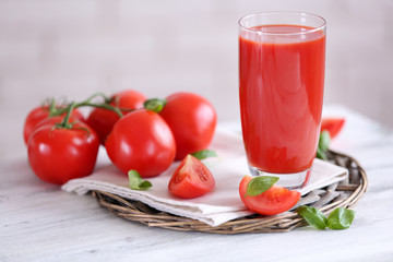Tomato juice and fresh tomatoes on wooden table close-up