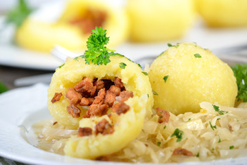 Österreichische Grammelknödel auf warmem Krautsalat rustikal serviert