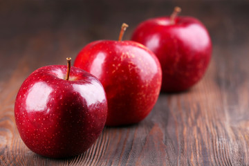 Red apples on wooden table, closeup