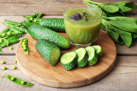 Glass of green healthy juice with spinach and cucumbers on table close up