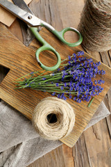 Fresh lavender with rope and scissors on wooden cutting board, closeup