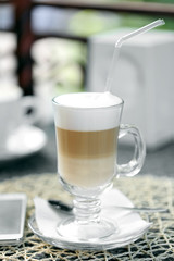 Glass of latte on table in cafe close-up