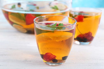 Fruity punch in glassware on wooden table, closeup