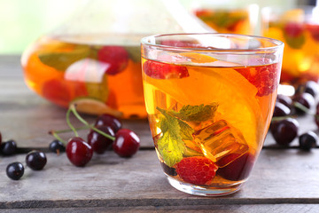 Punch with berries in glassware on wooden table, closeup