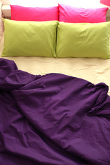Comfortable bed with colorful pillows in bedroom