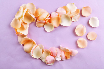 Beautiful heart of rose petals on purple background