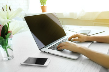 Fototapeta na wymiar Woman using laptop at workplace in office