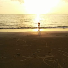 Mann am Strand bei Sonnenuntergang