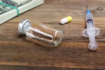 Medical Syringes, Vial  And Wad Of Dollar Bills Close-up