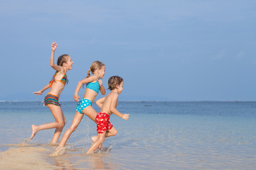 Three happy children  playing on the beach