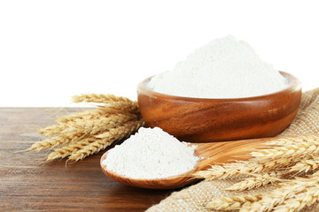 Wheat flour in bowl on wooden table isolated on white
