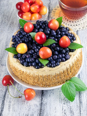 Celebratory cake with blueberries, sweet cherry, mint leaves and