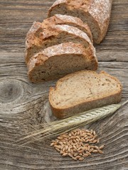 Rustic bread and wheat on an old wood table