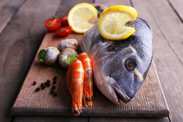 Dorado fish and other ingredients on wooden table, closeup