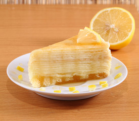 Lemon crepe cake with honey on plate.