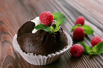 Delicious chocolate cupcake with berries on wooden table close up