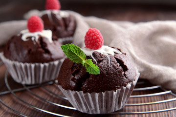 Delicious chocolate cupcakes with berries and fresh mint on table close up
