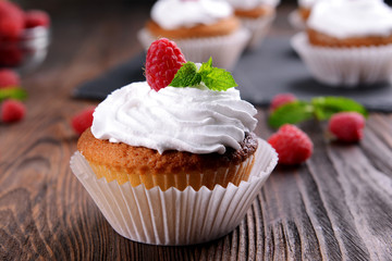 Delicious cupcake with berries and fresh mint on wooden table close up