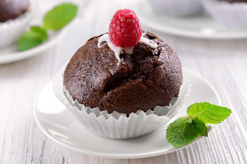 Delicious chocolate cupcake with raspberry on table close up