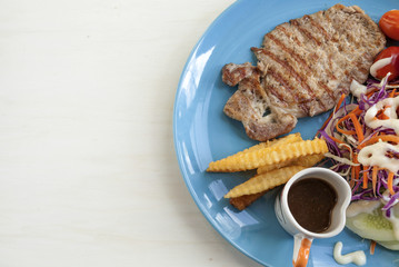 Grill pork serve with pepper sauce and salad with space on background