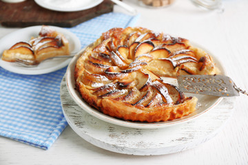 Obraz na płótnie Canvas Homemade apple pie on plate, on white wooden table background background