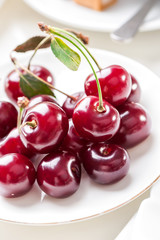 Plate of fresh cherries berries close-up 