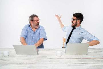 The two colleagues working together at office on white