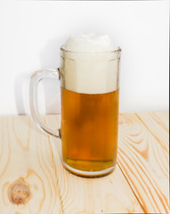 Mug of beer on wooden surface